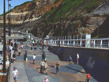 Kids on scooters and skateboards enjoying the new skate bowl at South Newcastle Beach