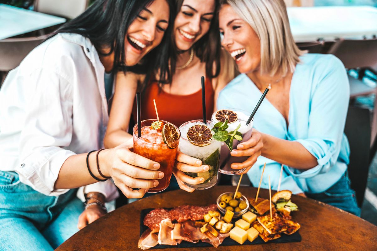 Friends sharing a drink over a charcuterie board