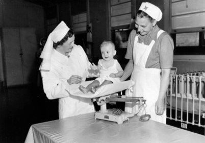 Nurses weighing a baby