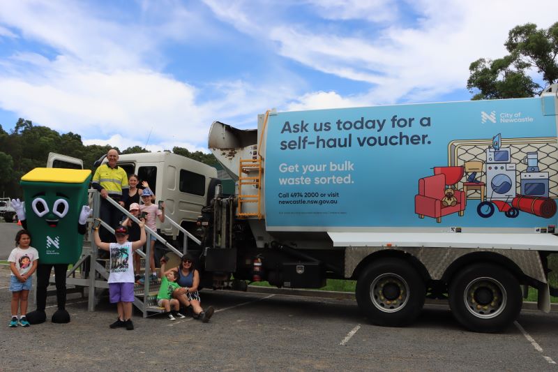 Executive Director Waste Services David Witherdin with kids tour attendees and Lucinda Bin mascot in front of a grabage truck at Summerhill Waste Management Centre