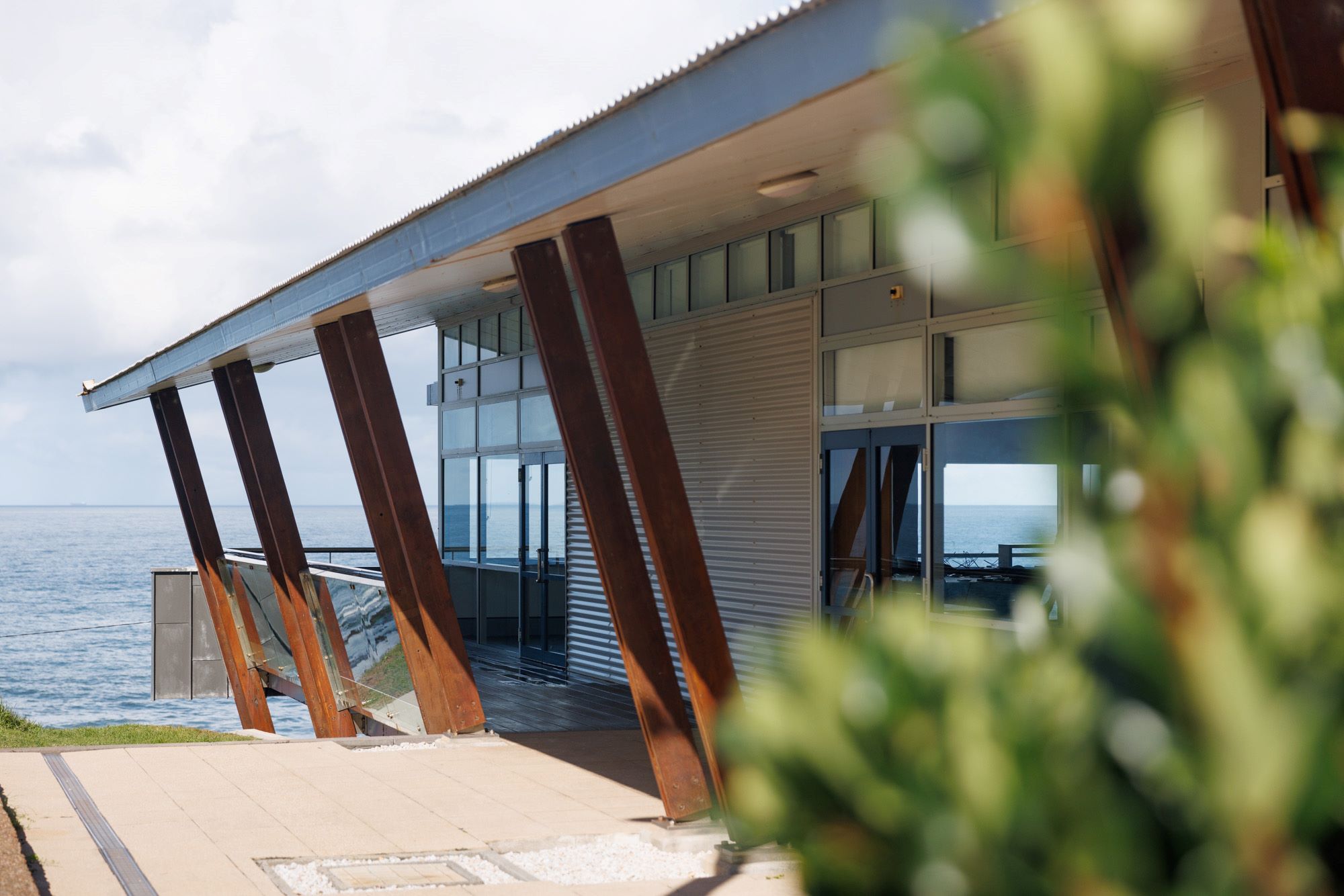 Side view of Fort Scratchley Function Centre showing balcony that wraps around building and overlooks ocean.